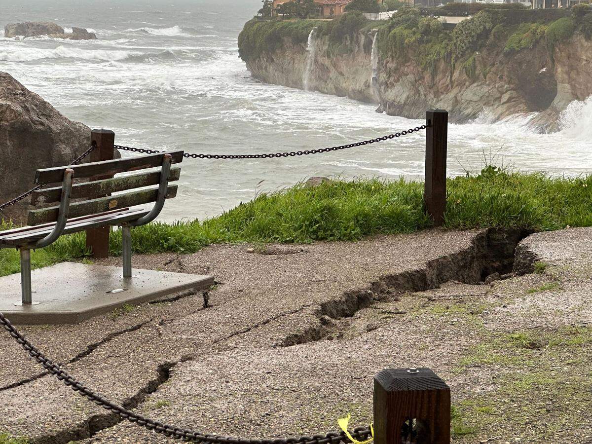 A cliffside bench is at risk of tumbling to the beach below as a crack grows behind it at Margo Dodd Park in Shell Beach. The bench is dedicated to Ralph Clement. The crack expanded dramatically overnight due to the storms Jan. 9, 2023.
