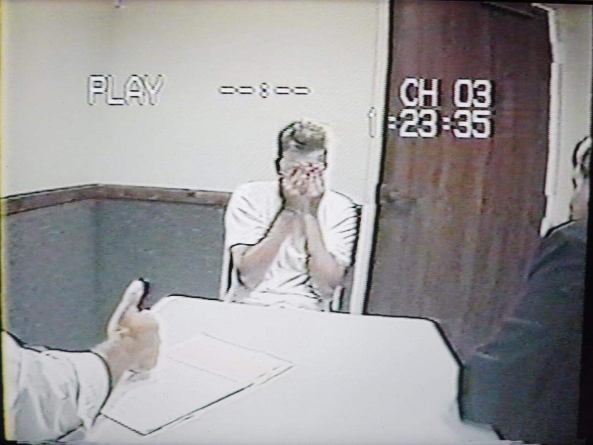 Paul Flores holds his hands to his face during questioning by the District Attorney’s Office in June 1996.