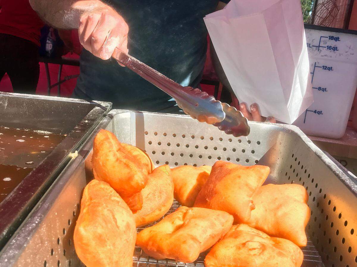 David Perlis, owner of The Second Line, fries his signature beignets at the Cambria farmers market in June 2022.