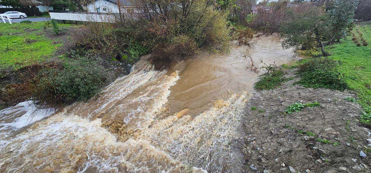 Laguna Lake rose well above its usual elevation during a storm, and spilled out underneath Madonna Road, on Feb. 19, 2024. The overspill also fed to the area below the Froom Ranch Way bridge near Dick’s Sporting Goods, creating a fast-moving creek.