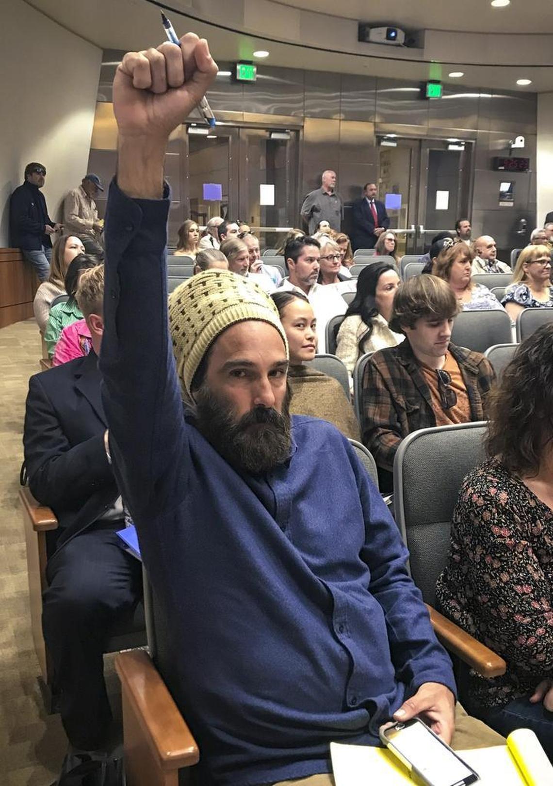 Kephas Neuhs, a Cal poly grad, third-year law student and longtime marijuana grower in the county under Proposition 215, raises his fist in support of cultivator rights as the San Luis Obispo County Board of Supervisors discusess details of the countywide marijuana ordinance.