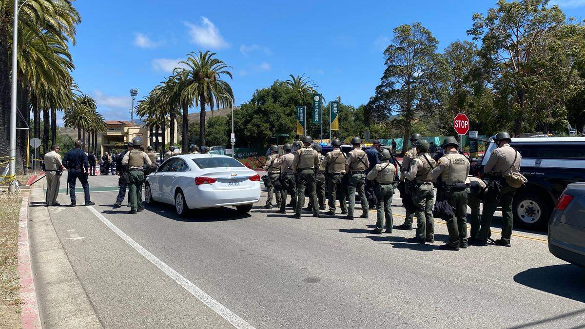 Sheriff’s deputies in riot helmets assemble as backup while detain eight pro-Palestine protesters who blocked the intersection at California Boulevard and Campus Way near Cal Poly on May 23, 2024.