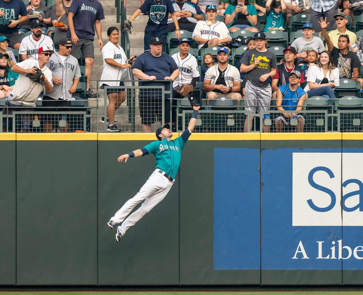 Rightfielder Mitch Haniger (17) of the Seattle Mariners jumps to make a catch for an out on a ball hit by Vladimir Guerrero (27) of the Toronto Blue Jays during the first inning of a game at T-Mobile Park on Aug. 13, 2021 in Seattle. The Mariners edged the Blue Jays, 3-2.