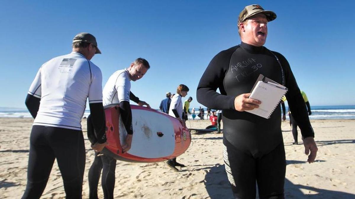 Former San Luis Obispo County Veterans Services Officer Dana Cummings (right) directs surfers and volunteers during a Pismo Beach event in October 2011.