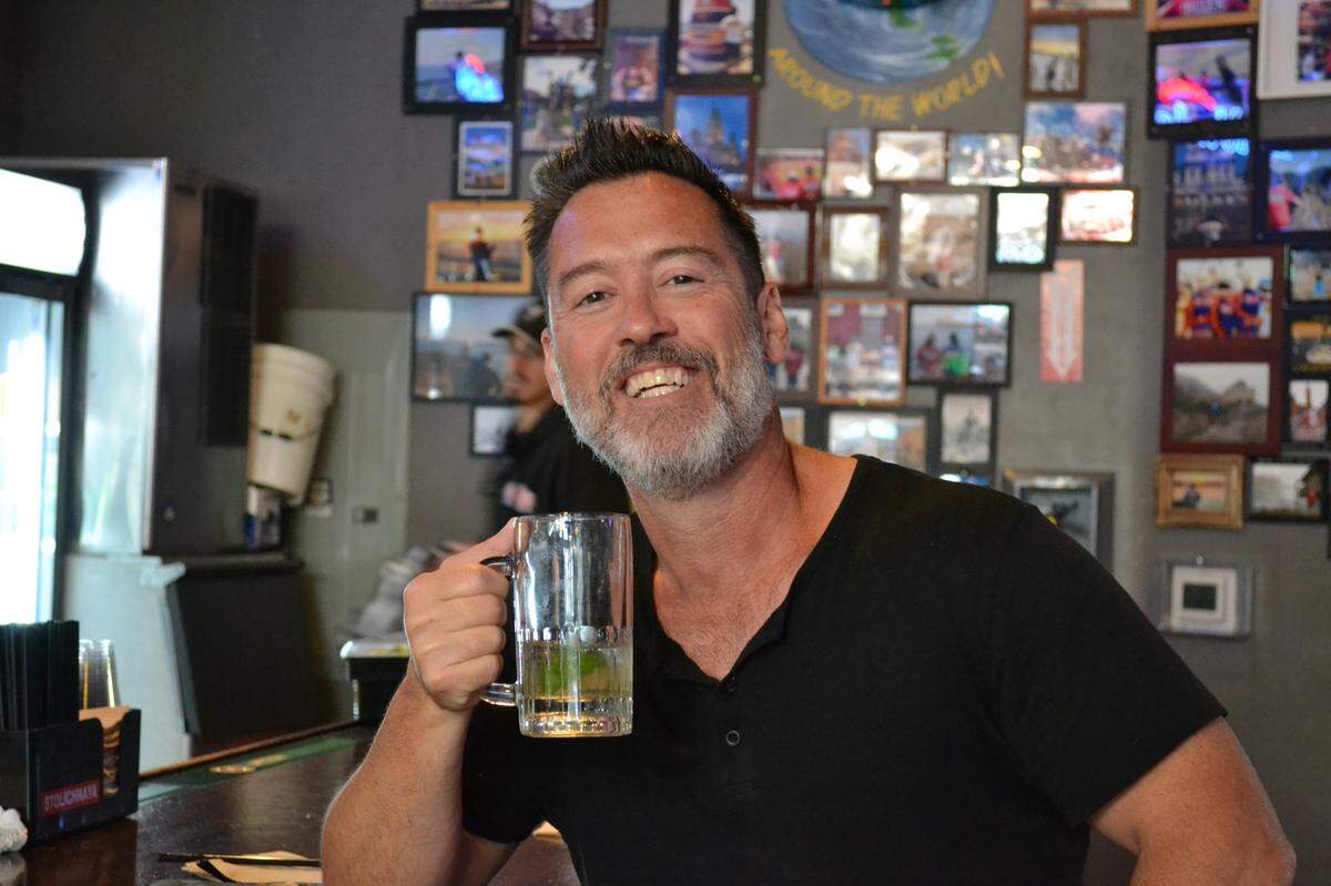 Regular Brian DeLorme poses with his namesake, “The Brian,” at Bulls Tavern in June 2023. The cocktail appears on the menu as a Mandarin Mule, made of Absolut Mandarin Vodka on the rocks with ginger beer and a dash of lime.