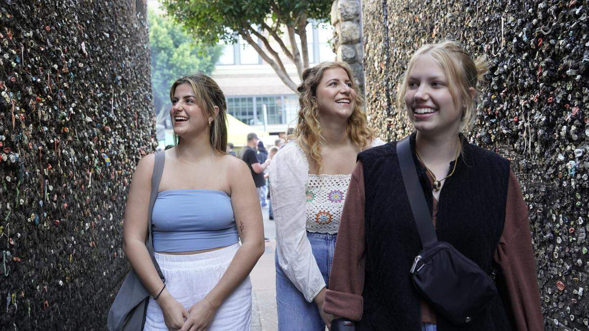 Dallas, Texas resident Taylor Morris (left), Auburn University student Brooke Morris and Mission Prep College High School sophomore Elia VanderHorst stroll through Bubblegum Alley on Thursday, May 18, 2023.