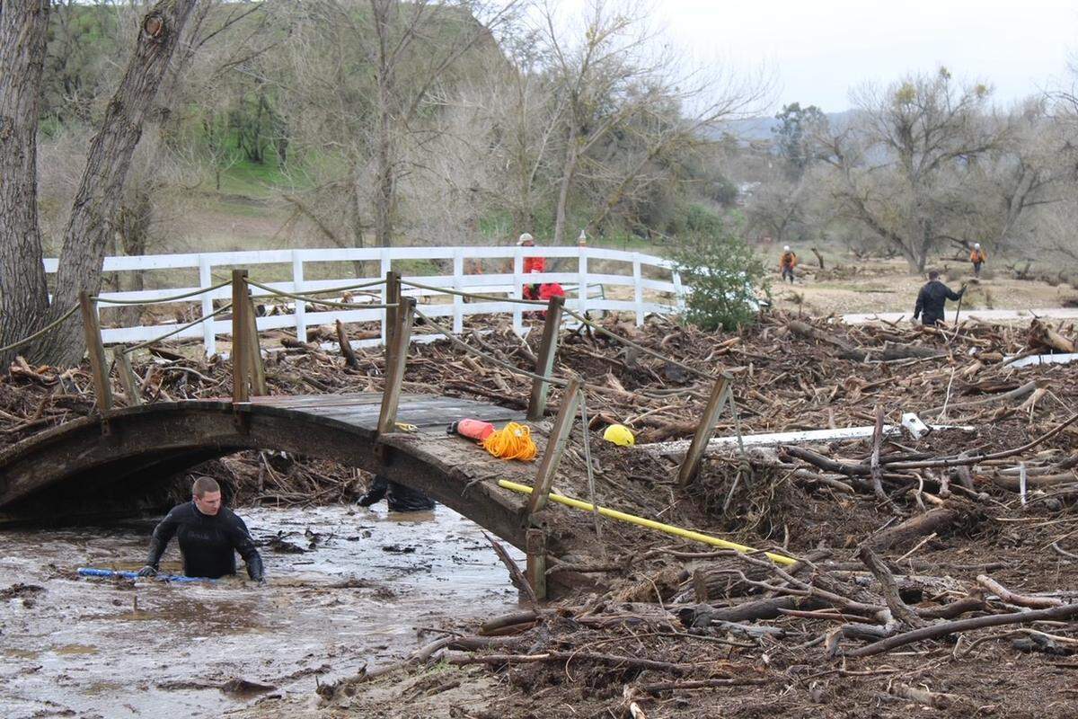 Searchers check through floodwaters and debris for any sign of 5-year-old Kyle Doan on Wednesday, Jan. 11, 2023, two days after he disappeared in swollen San Marcos Creek near San Miguel.