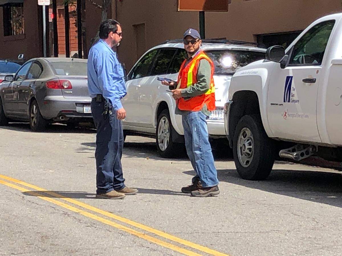 Officials from The Gas Company stand near the site of a hydraulic oil spill at Osos and Monterey streets in downtown San Luis Obispo on Tuesday, July 23, 2019. A utilities union worker threatened a protest if the City Council moved forward with a vote on its draft energy policy.