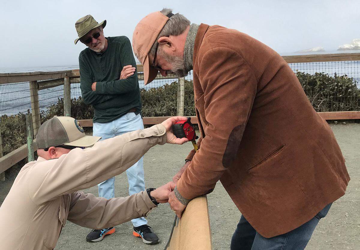 Steve McGrath, at right, helps California State Parks employee Evan Feeney install one of two memorial plaques on a bench at the elephant seal rookery south of Piedras Blancas, as Richard Greek looks on July 11, 2022. The bench honors Richard Tanner, the late husband of columnist Kathe Tanner. He was among the first docents at the rookery.