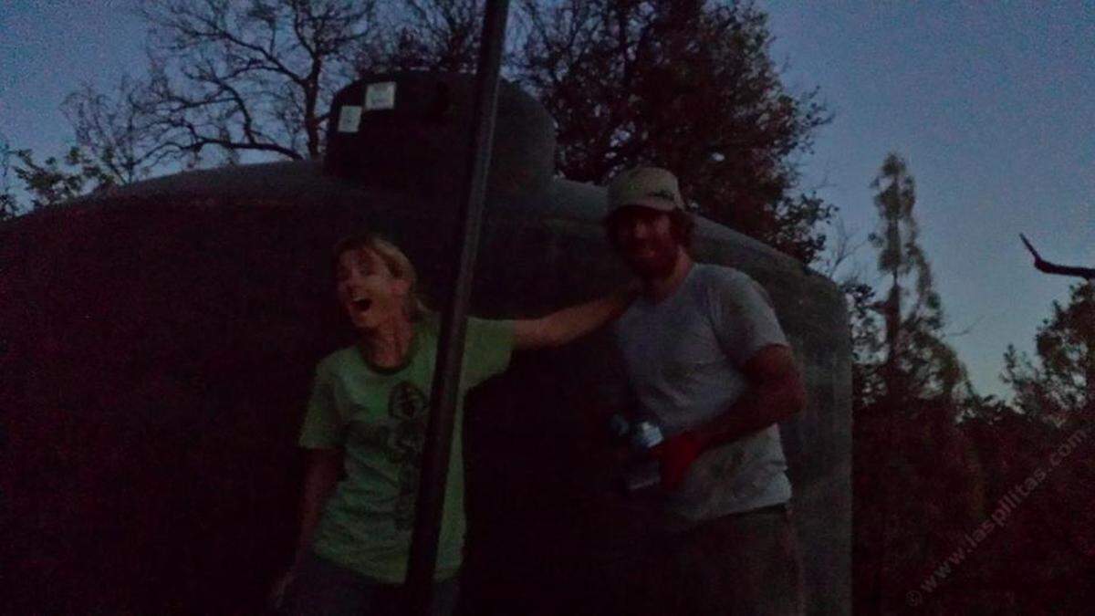 Las Pilitas Nursery owners Penny Nyunt and Ian Wilson pose in the dark in front of the new water tank after a wildfire melted their first one in summer 2016.