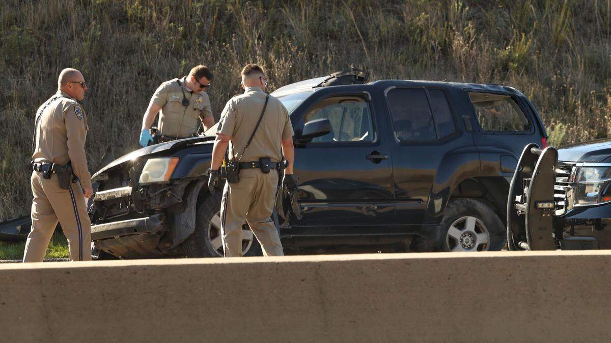 CHP officers inspect an SUV damaged in a crash that backed up Highway 101 traffic on the Cuesta Grade on Tuesday, Dec. 31, 2024.