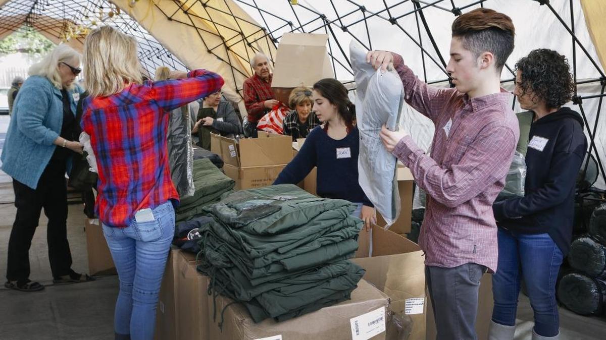 Community volunteers set out jackets in preparation for the annual Christmas Dinner to feed and outfit the Homeless for the winter with sleeping bags, sweatshirts, jackets, socks, underwear, beanies and toiletries at the Odd Fellows Hall in San Luis Obispo.