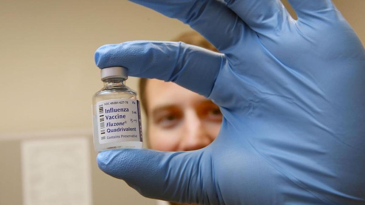 Matt Maurer, the epidemiologist for Coconino County, holds a vial of influenza vaccine at the county health department in Flagstaff, Ariz. The county, just like the rest of the state, has seen a spike in flu cases and it has overwhelmed some providers.
