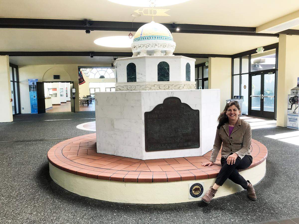 Cara O’Brien, Hearst Castle’s museum director, rests briefly on a new display at the monument’s visitor center. The display designed and built by Castle staff, shows off national and state historic designation plaques that had for years been mounted on a fence outside the Visitor Center. O’Brien said she’s confident that now more people will be able to see the plaques, which underscore the Castle’s historic significance.
