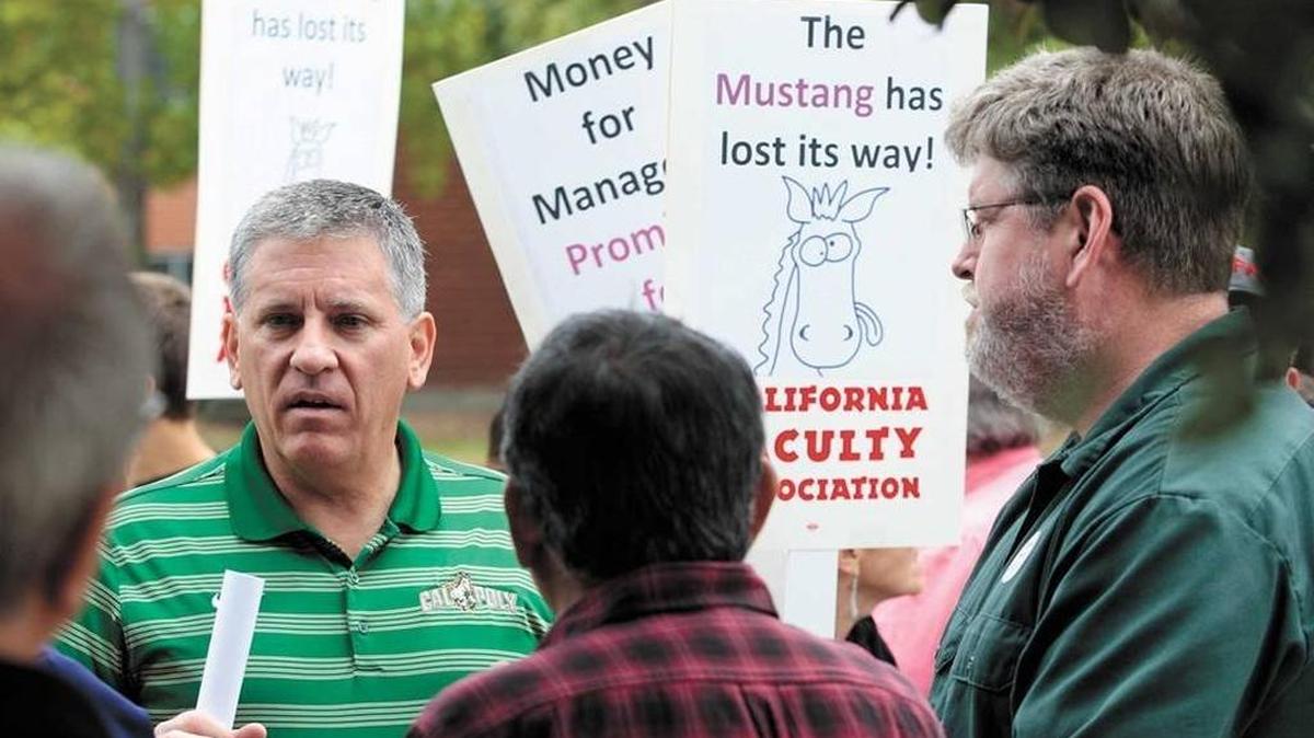 Cal Poly President Jeff Armstrong (left, green shirt) and Cal Poly faculty union president Graham Archer (right, green shirt) talk at a protest in May led by faculty pushing for a pay increase.