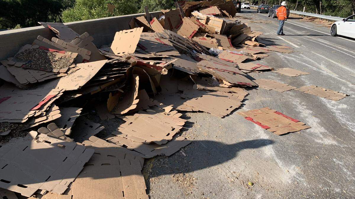A trailer overturned, spilling cardboard onto Highway 101 north of San Luis Obispo on June 1, 2023.