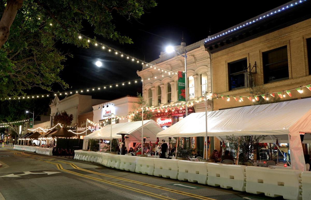 Diners eat under a full moon on Monterey Street in downtown San Luis Obispo in November. Zigzag lighting and parklets have been key additions to the downtown, according to community leaders.