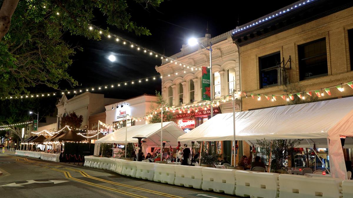 Diners eat under a full moon on Monterey Street in downtown San Luis Obispo. Shoppers can earn $25 gift cards by spending money at stores, restaurants and other local businesses.