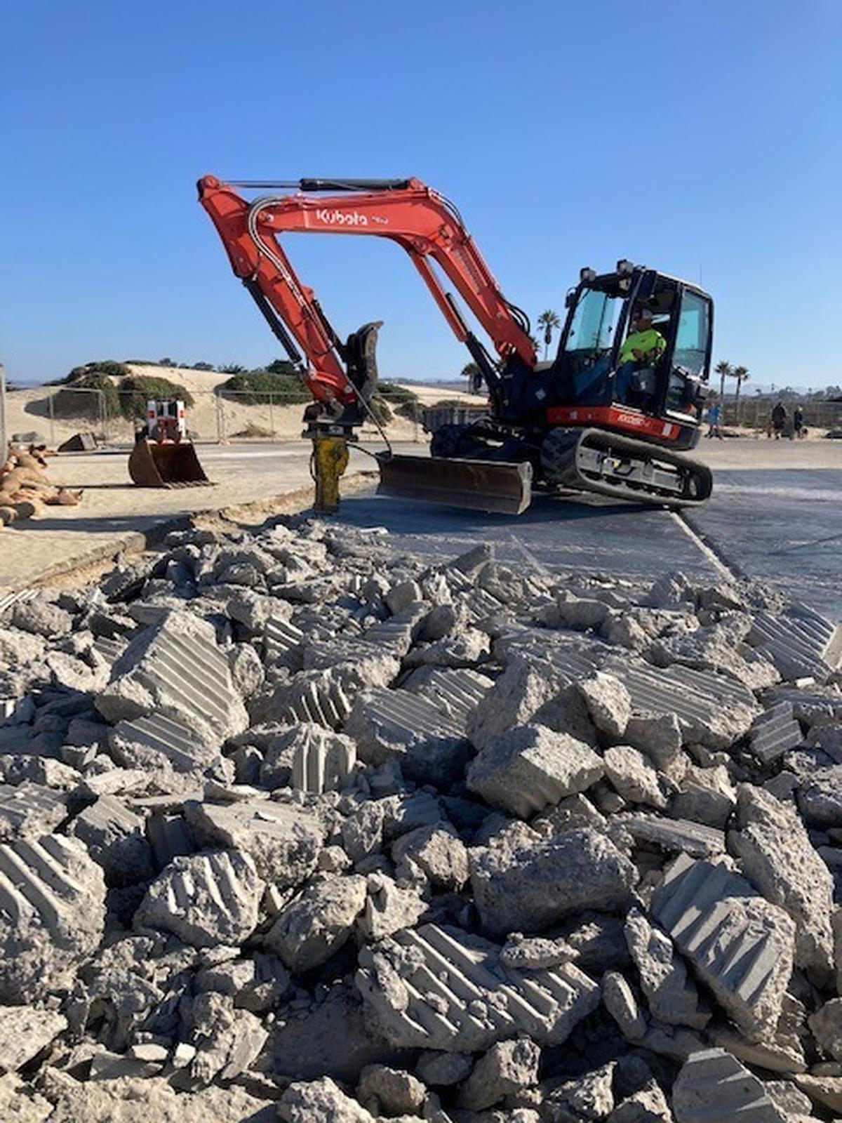A worker uses heavy equipment to jackhammer a concrete ramp the Grand Avenue entrance to the Oceano Dunes State Vehicular Recreation Area on Aug. 31, 2022. State Parks said the work was not up to standards and ordered it redone.