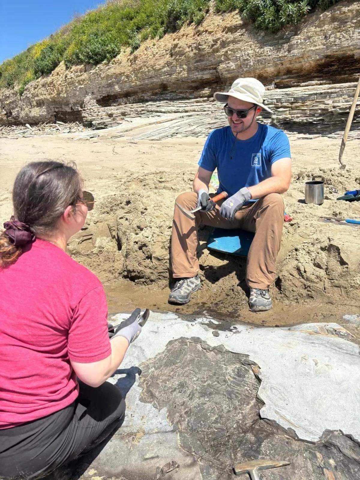 Jonathan M. Hoffman, a curator at the Santa Barbara Museum of Natural History, talks to a member of the team working to excavate a whale fossil found along the Gaviota Coast. The team had to deal with waves, high tide and wet sand.