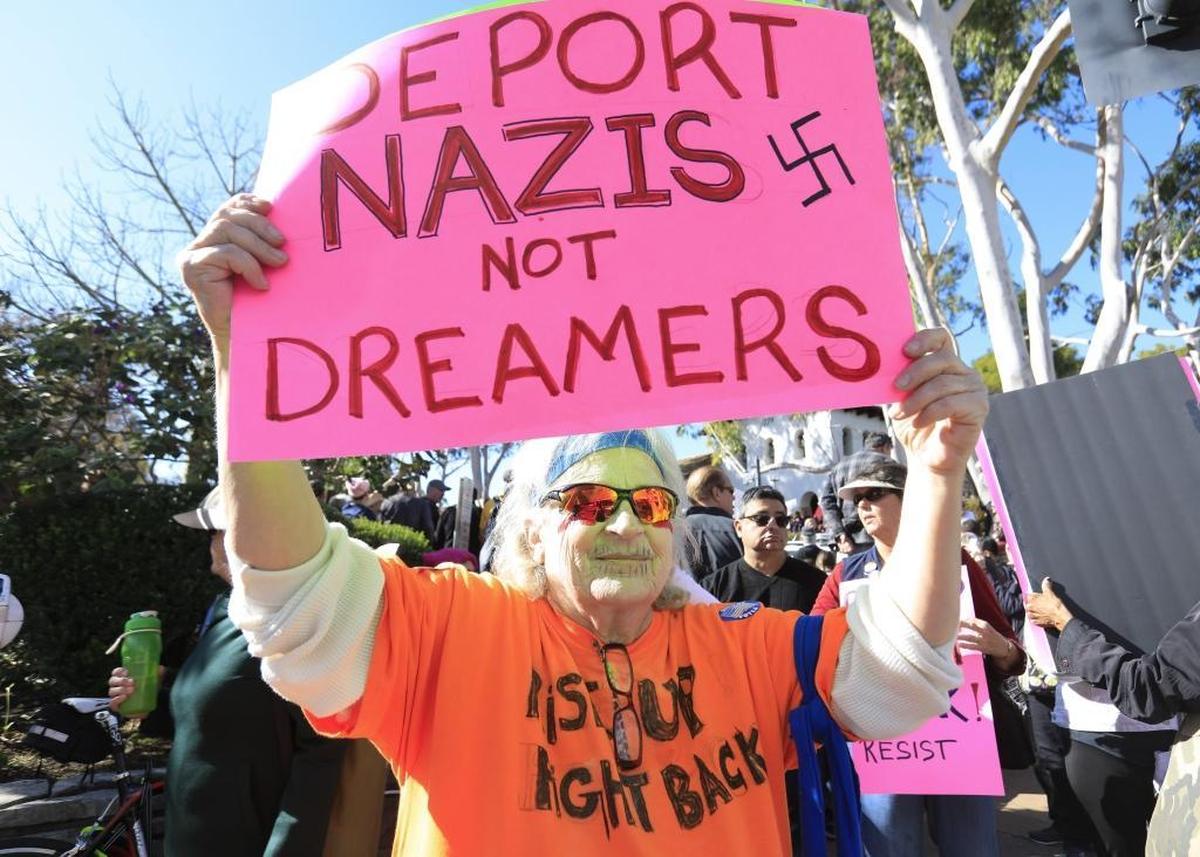 Signs from Saturday’s “Hear Our Vote: Voices of Resistance Rally.” Nancy MacNeil of Oceano holds her sign.