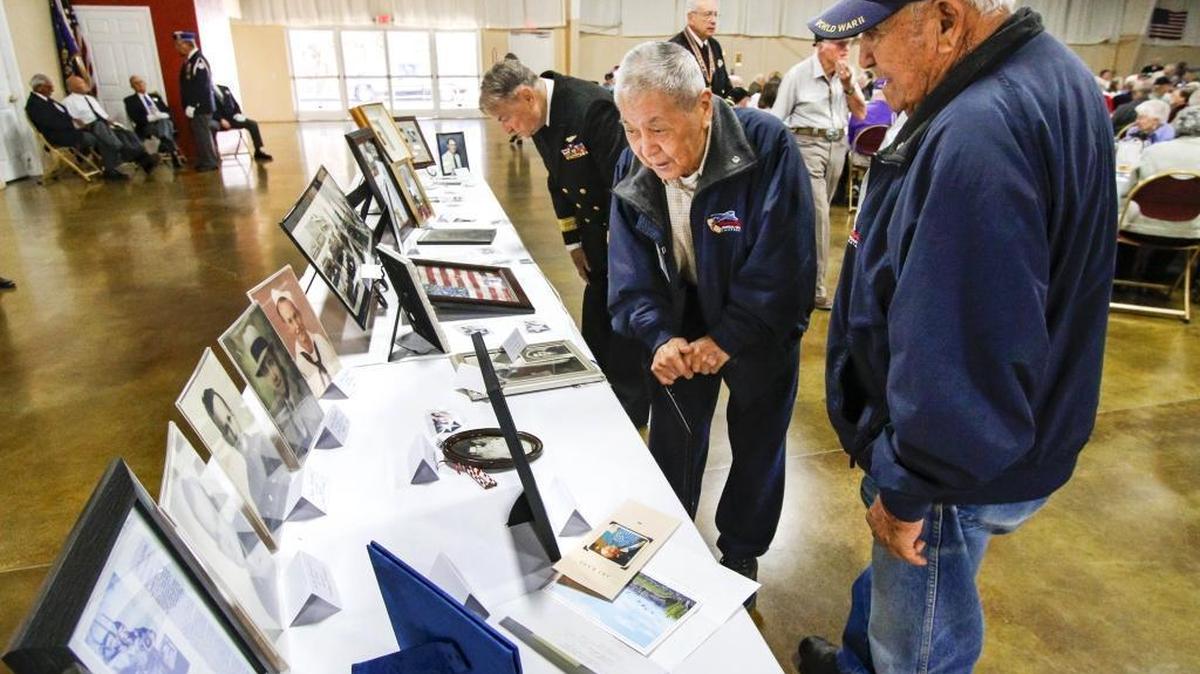 WWII veterans Bindo Grasso, right, and Harry Msatani have been friends for 70 years. Here they look over the Faces of Valor display at the WWII & Korean War Veterans Tribute at the Madonna Expo Center.