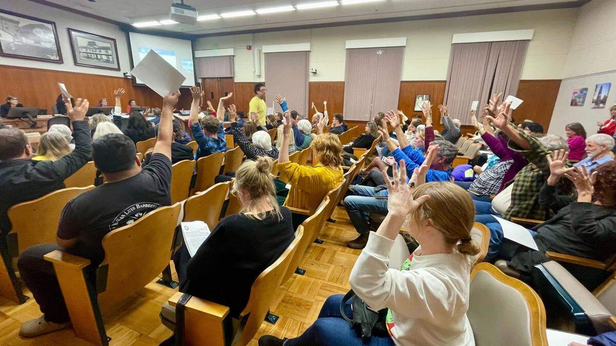 Attendees shake their hands in support after a resident speaks to the San Luis Obispo City Council on Nov. 7, 2023, about how parking challenges are negatively impacting their family and the downtown.