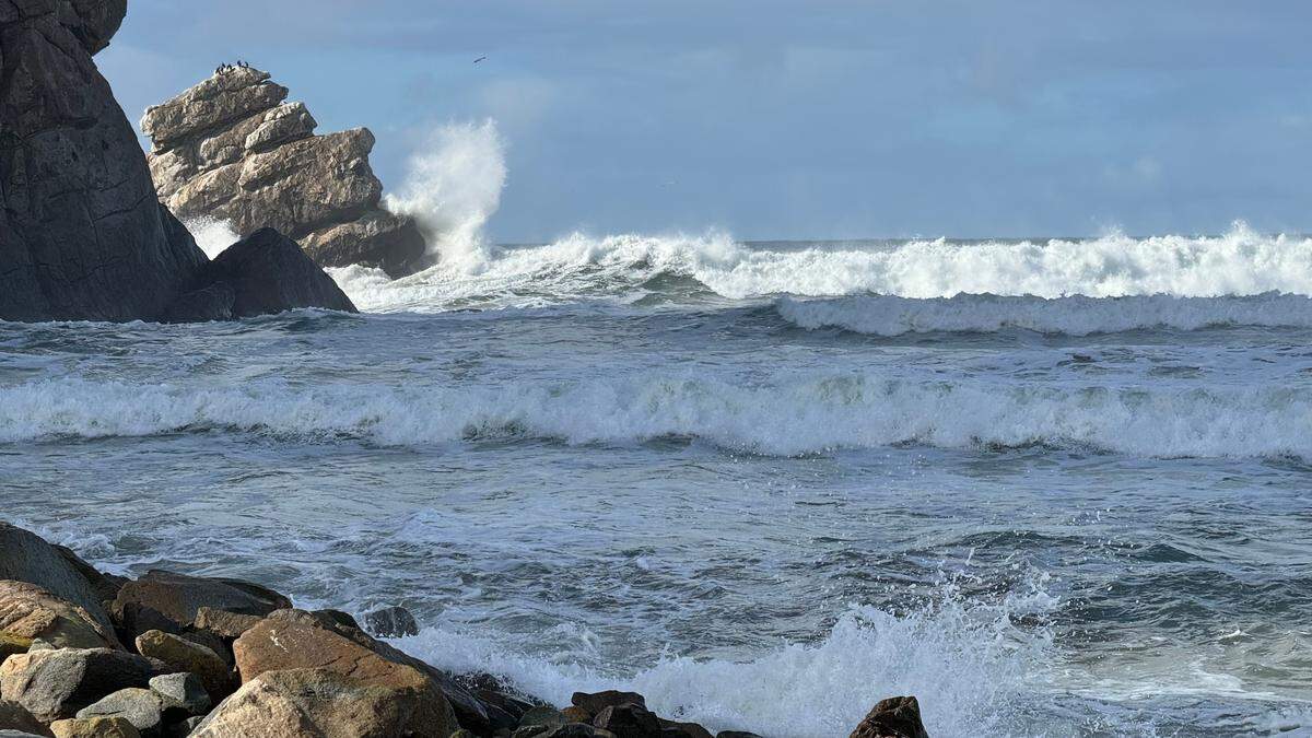Waves crash on the north side of Morro Rock, splashing around the familiar formation of the man in the bathtub, on Saturday, Dec. 30, 2023.