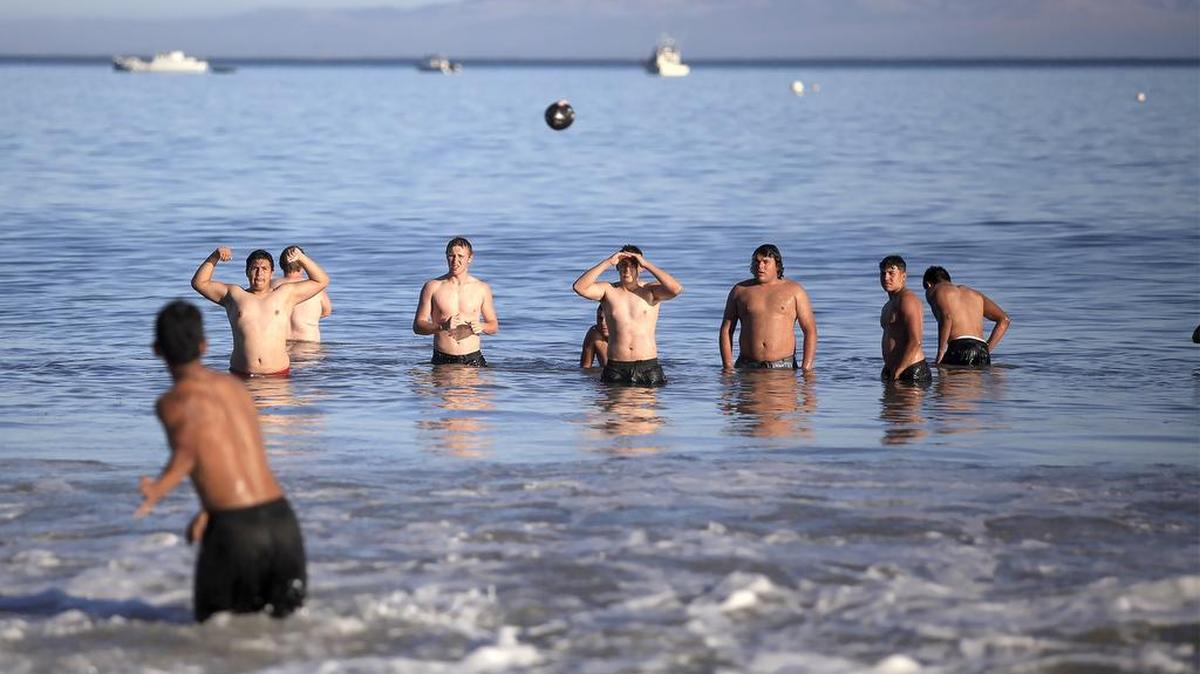 Members of the Woodlake High School football team relax by throwing a football in the ocean at Olde Port Beach in Avila Beach on Saturday. They came to San Luis Obispo to participate in the 12th Annual Central Coast Shootout on Saturday. The passing competition, hosted by Mission Prep, brought together teams from the Central Coast, Bay Area and Central Valley.