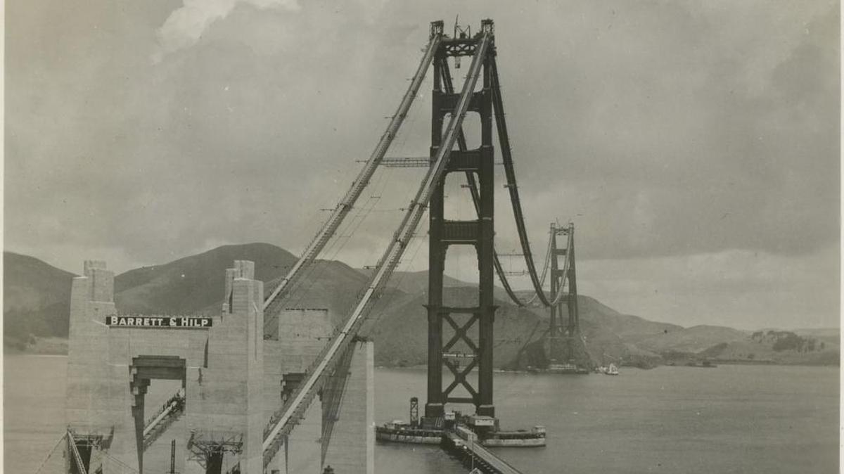 A photo from the William M. McCarthy Photograph Collection taken on July 1, 1936, shows the Golden Gate Bridge under construction. The towers and suspension cables have been built, but the work on the bridge deck has not started.
