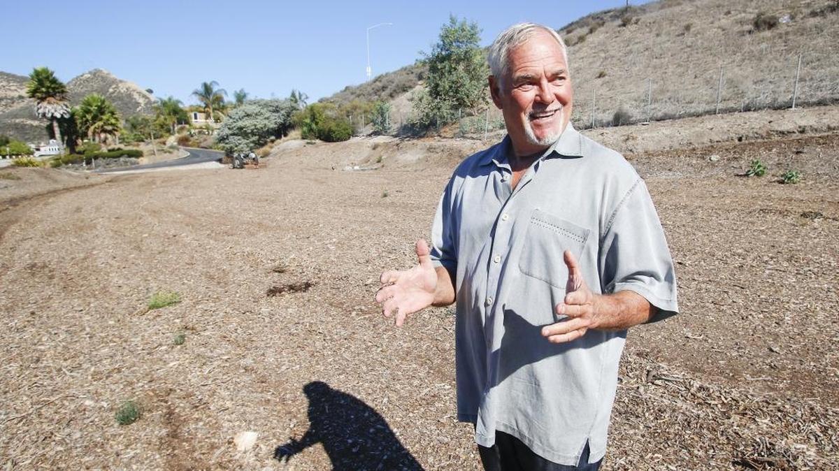 Mike Spangler discusses his dispute with the city of Pismo Beach over whether he is required to sign an open space easement for a portion of his property. In the background is his home.