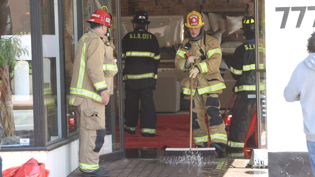 A structure fire at 781 Marsh St. in downtown San Luis Obispo briefly shut down the street on May 14, 2025. Firefighters broom water out of Habitat Home and Garden, at the corner of Marsh and Garden streets.