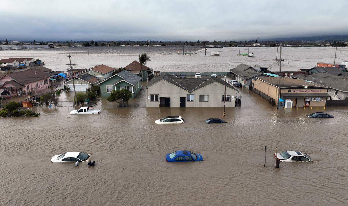 This aerial photograph shows cars and homes engulfed by floodwaters in Pajaro, California, on Saturday, March 11, 2023. Residents were forced to evacuate in the middle of the night after an atmospheric river surge broke the the Pajaro levee and sent flood waters flowing into the community. 