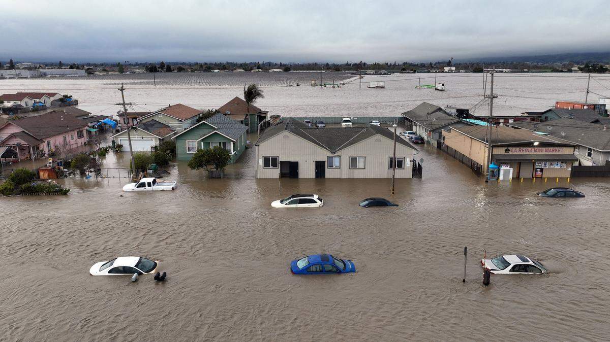 This aerial photograph shows cars and homes engulfed by floodwaters in Pajaro, California, on Saturday, March 11, 2023. Residents were forced to evacuate in the middle of the night after an atmospheric river surge broke the the Pajaro levee and sent flood waters flowing into the community.