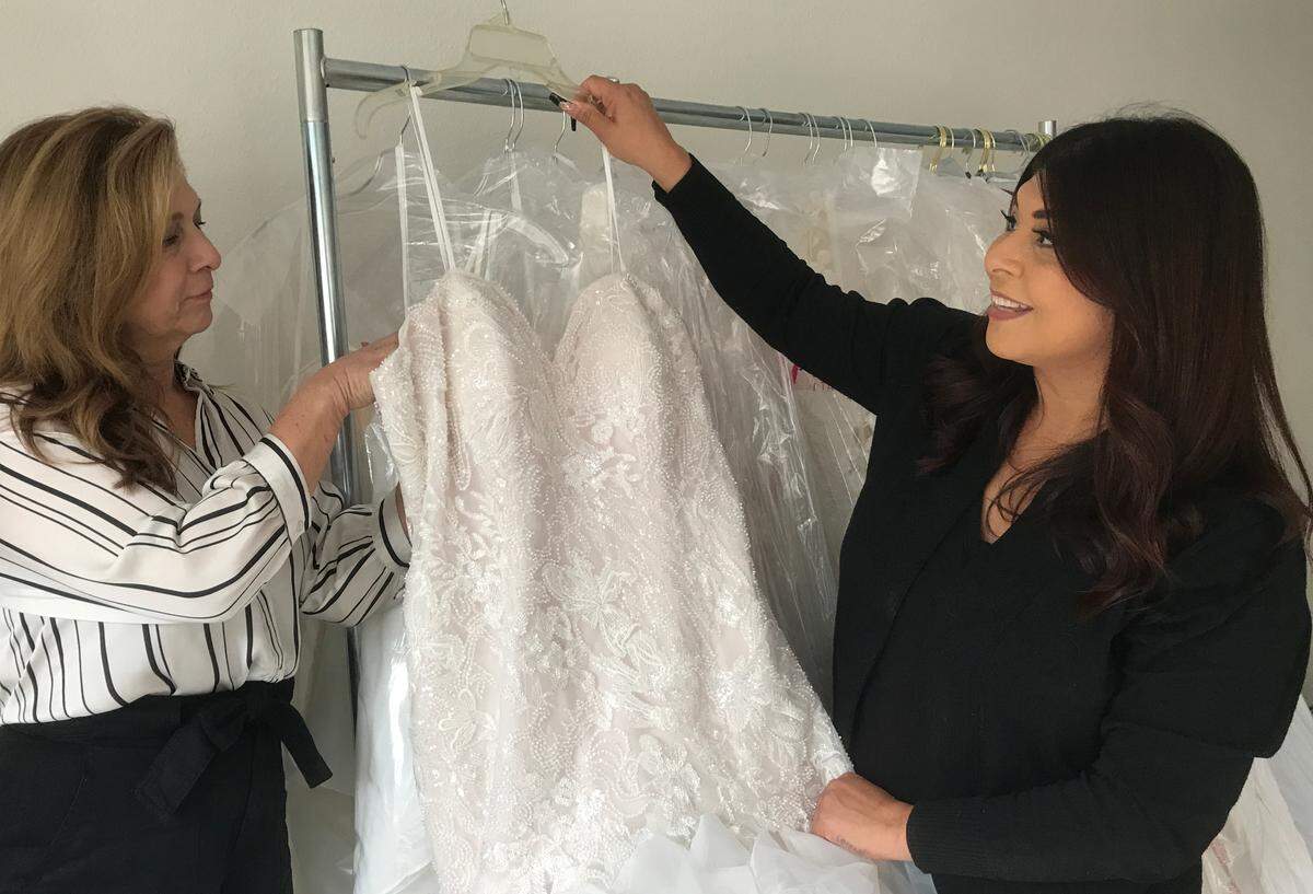 From left, mother and daughter Gail and Crystal Reynoso, owners of new Cambria wedding shop A Little Love Bridal by the Sea, check in a $2,700 bejeweled-lace gown by Italian designer Eddy K.