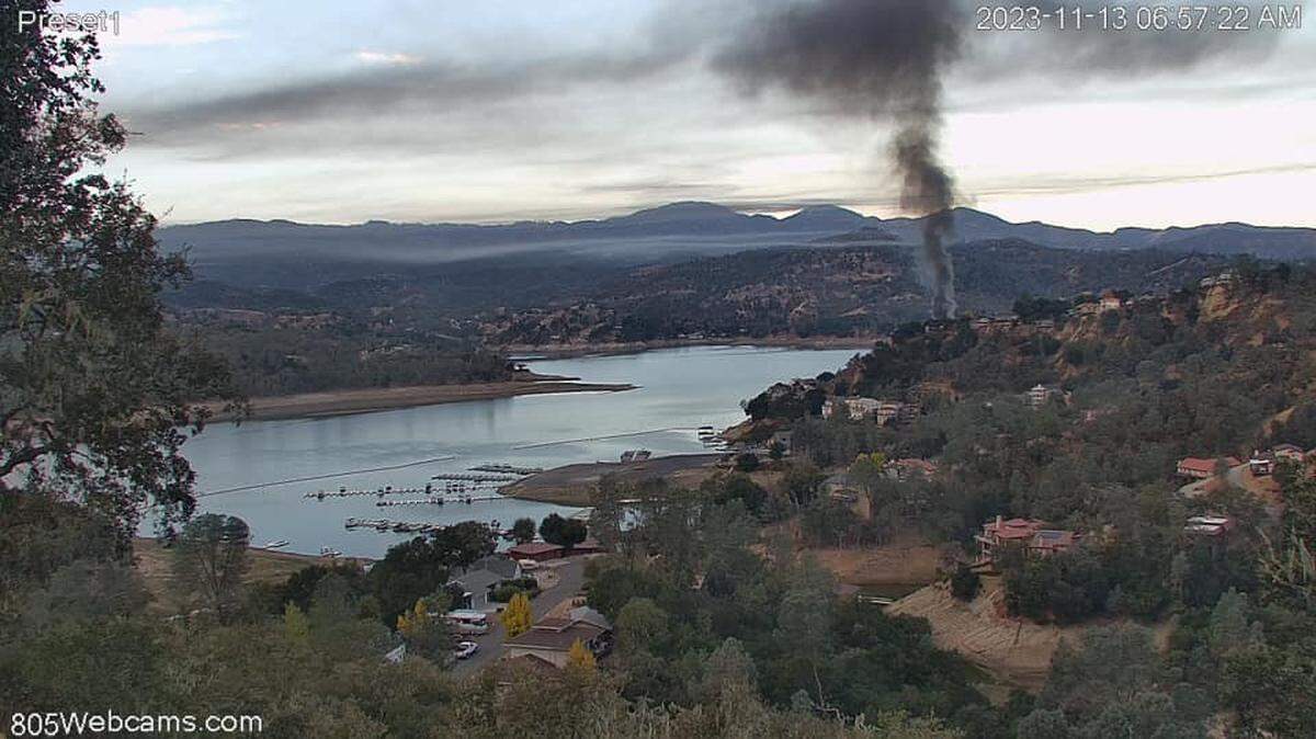 A column of smoke rises from a fire at a home in the Oak Shores neighborhood at Lake Nacimiento on Nov. 13, 2023.