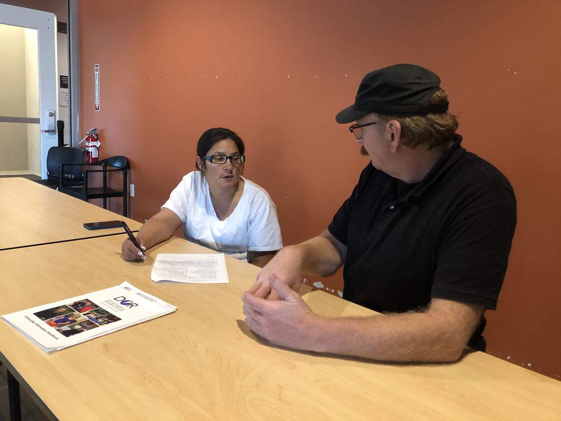 Social worker John Klevins meets with a homeless woman in SLO at 40 Prado shelter in 2019.