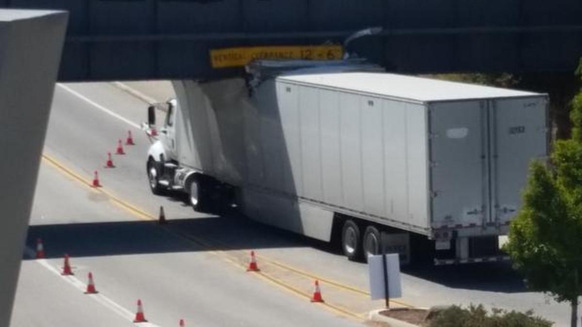A semi-truck carrying mattresses was temporarily stuck under a Highland Avenue bridge on the Cal Poly campus Tuesday afternoon, marking at least the third time a vehicle has struck the same bridge this year.