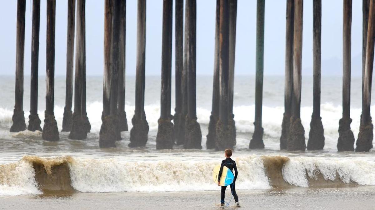 Kids braved the chilly waters on a cloudy day at Pismo Beach pier. Storm surge and high tides created pools of water high up on the beach. A young surfer watches the waves before he attempts to go out. Over the rainy weekend, Pismo Beach received 0.4 inches of rain; San Luis Obispo received 0.56 inches; and Santa Margarita received 1.1 inch of rain, according to San Luis Obispo County Water Resources.