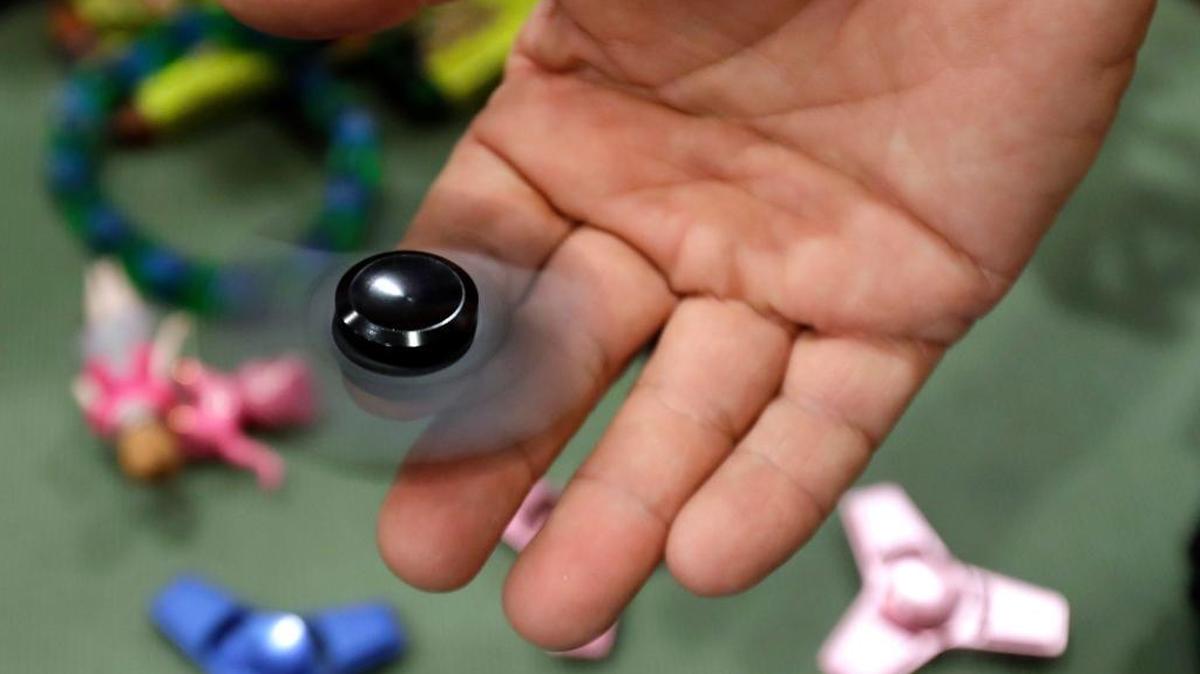 Funky Monkey Toys store owner Tom Jones plays with a fidget spinner in Oxford, Michigan. The popular toys are the focus of FidgetCon on Nov. 11 at the South Bay Community Center in Los Osos.