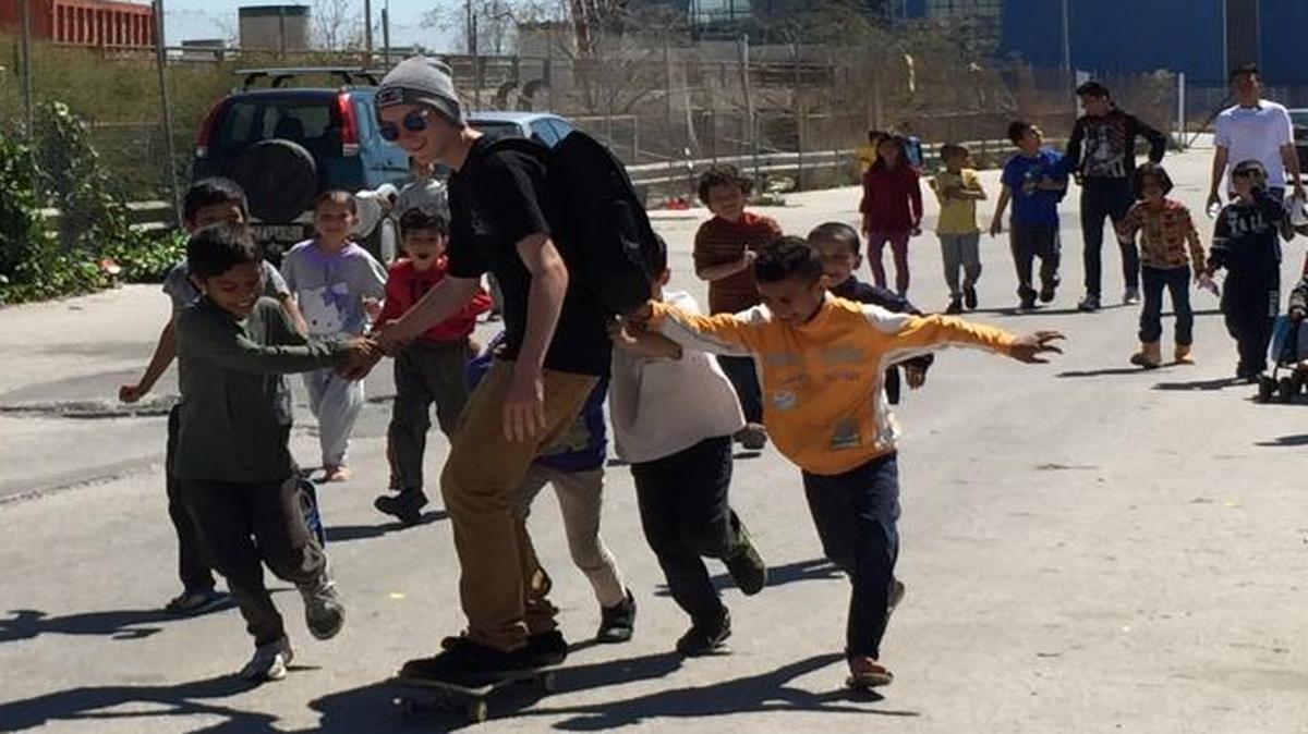 Team member Cameron Calmere, 14, of Atascadero, shows some of his skateboarding moves to Afghan refugees in Athens, Greece. Calmere was part of a nine-person team volunteering in the city to help refugees as they seek safety in Europe.