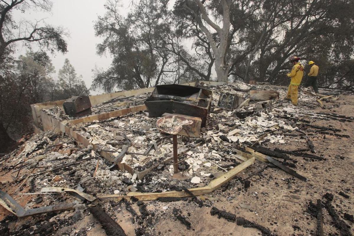 Cal Fire’s Gene Potkey, left, and Macho Rosa with the U.S. Forest Service conduct damage inspection at Cal Shasta.