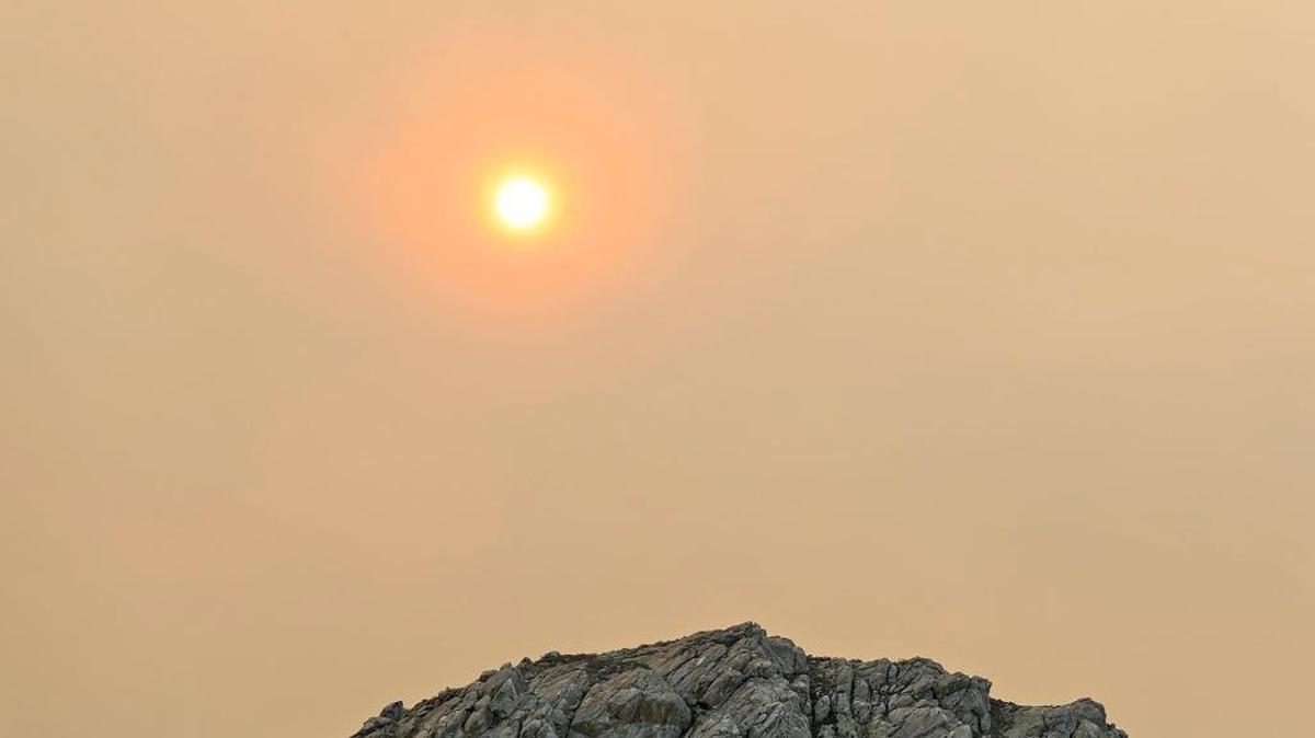 Smoke from the Thomas Fire has reached has reached almost to the Oregon border. Here, the sun above Morro Rock has a reddish cast from the smoke on Sunday.