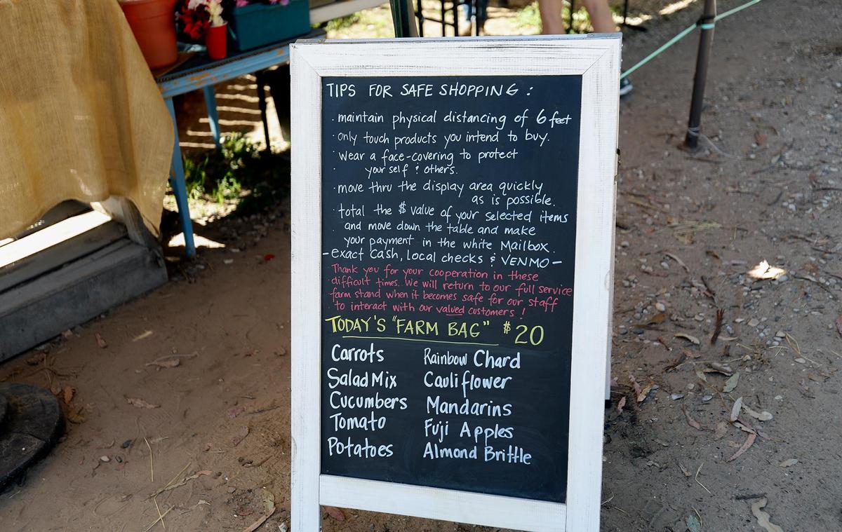 Farmworkers at the Rutiz Family Farm in Arroyo Grande talk about what life is like during the coronavirus pandemic. A sign in front of the outdoor store explains the process to buy fruits, vegetables and flowers.