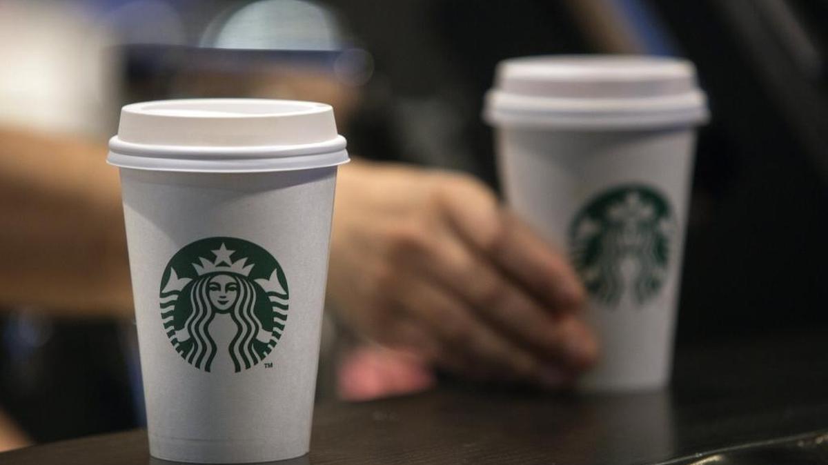 Beverages sit on a counter inside a Starbucks coffee shop.