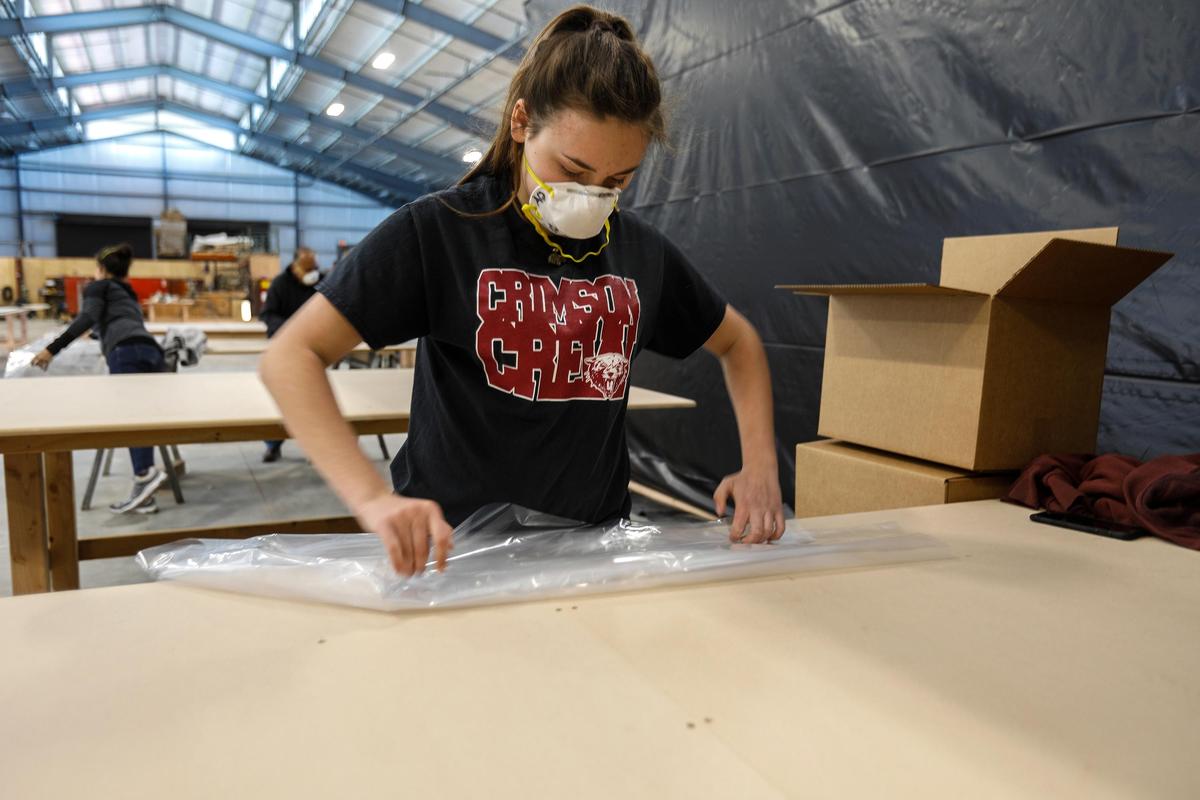Amanda Daniels folds a plastic protective gown as the last step to prepare it for shipping. Daniels Wood Land in Paso Robles typically creates playground equipment, movie props and tree houses. Due to the coronavirus outbreak, the company has shifted gears to produce plastic gowns for emergency workers and hospitals.