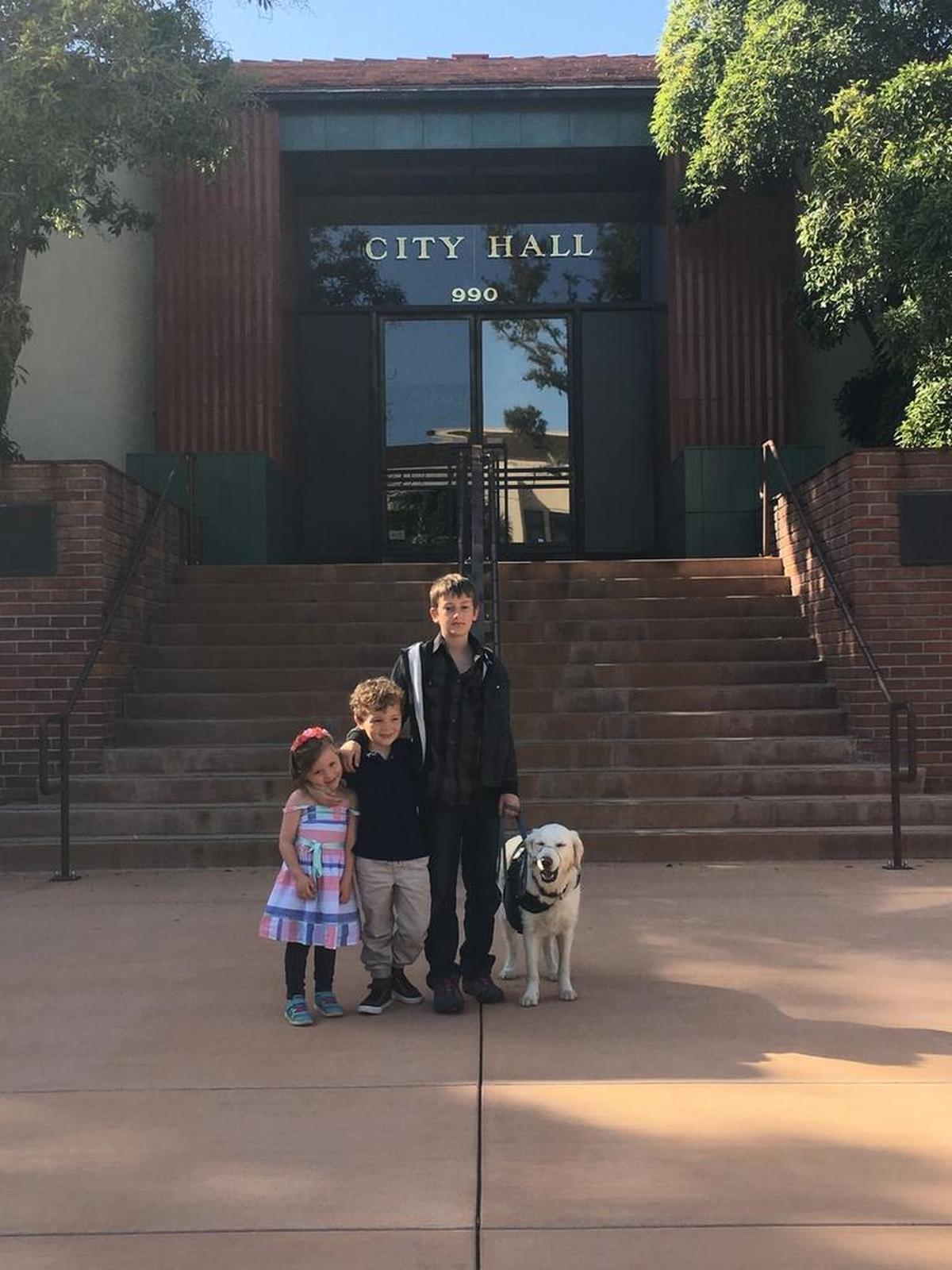 From left, Ruby Reinhart, Lucas Reinhart and Kavi Holmes pose for a picture outside the San Luis Obispo City Hall.