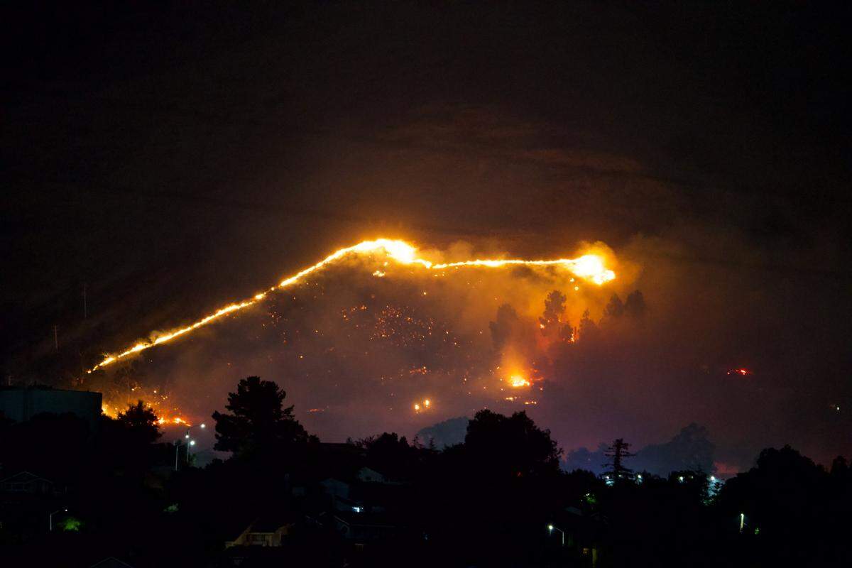 An early morning fire burns on the hill behind Bishop Street, forcing evacuations in San Luis Obispo on Tuesday, Aug. 20, 2024.