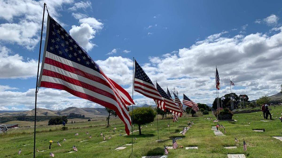 Flags fly at Los Osos Memorial Park and Mortuary Park during a 2019 Memorial Day ceremony.