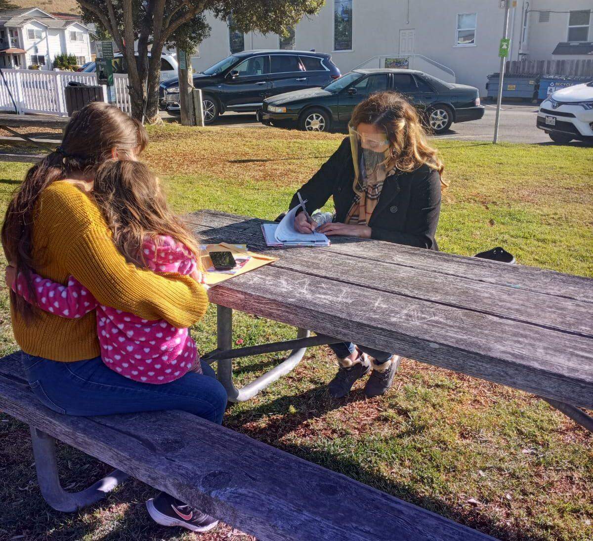 Promotora Karla Najera helps a family fill out paperwork. The Promotores Collaborative of San Luis Obispo County has been supporting Spanish-speaking families and working with the county Public Health Department to distribute information about the coronavirus.